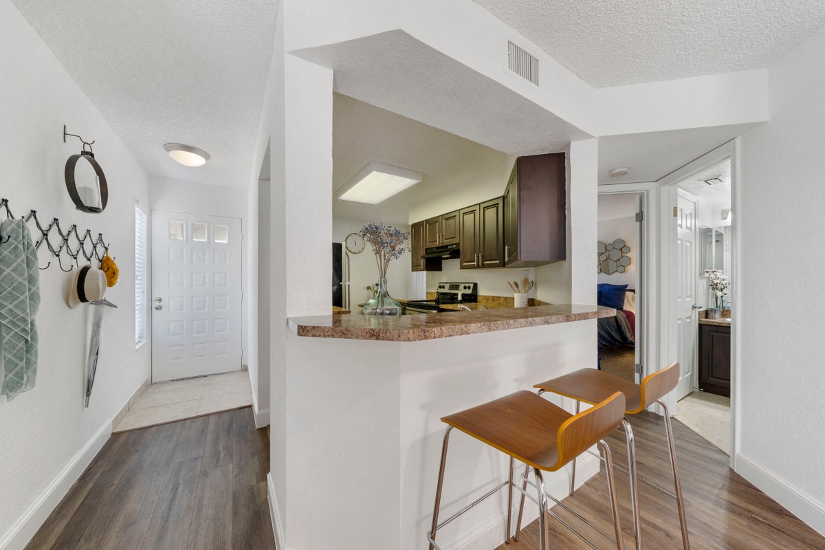 Looking into kitchen from bar with two stools